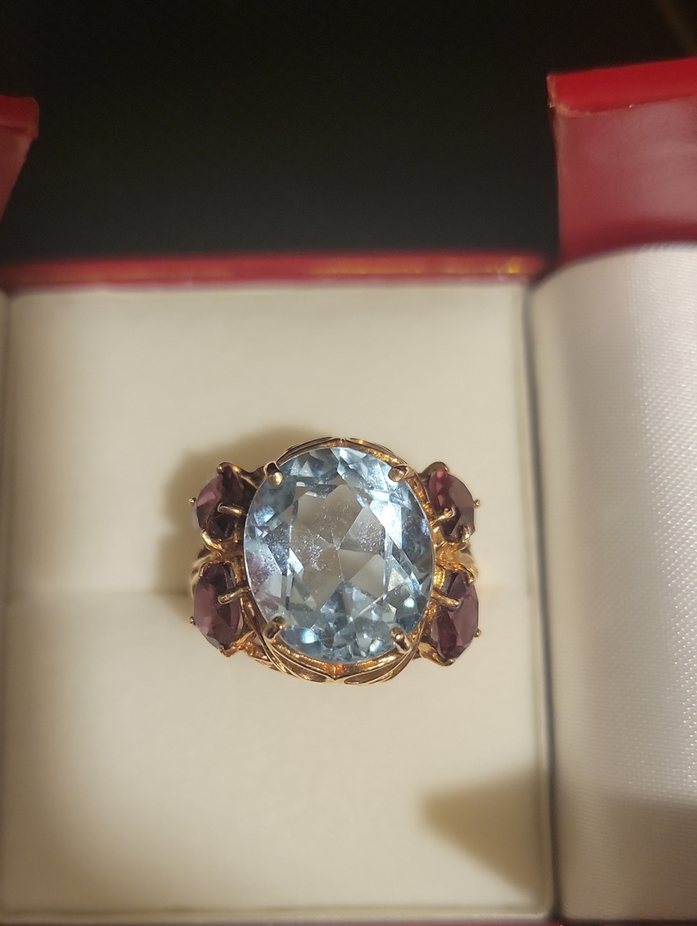 10K Gold Ring with Large Light Blue Topaz Center Stone and Garnet Side Stones.